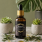 Bottle of Naiga Naturals Beard Growth Oil with plants and rosemary on a marble surface