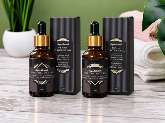 Two 30ml bottles of Naiga Naturals Beard Growth Oil with gold droppers and matching black boxes.
