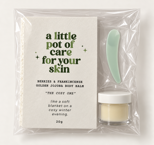 Little Pots 20g Berries & Frankincense Golden Jojoba Body Balm with a mint-green spatula and The Cosy One card in clear packaging.
