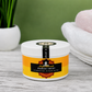 Jar of Mango Twist whipped hair and body butter on a wooden surface with a green background
