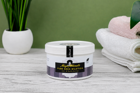 Jar of Naiga Naturals Pure Shea Nilotica body butter on a wooden surface with a green background.